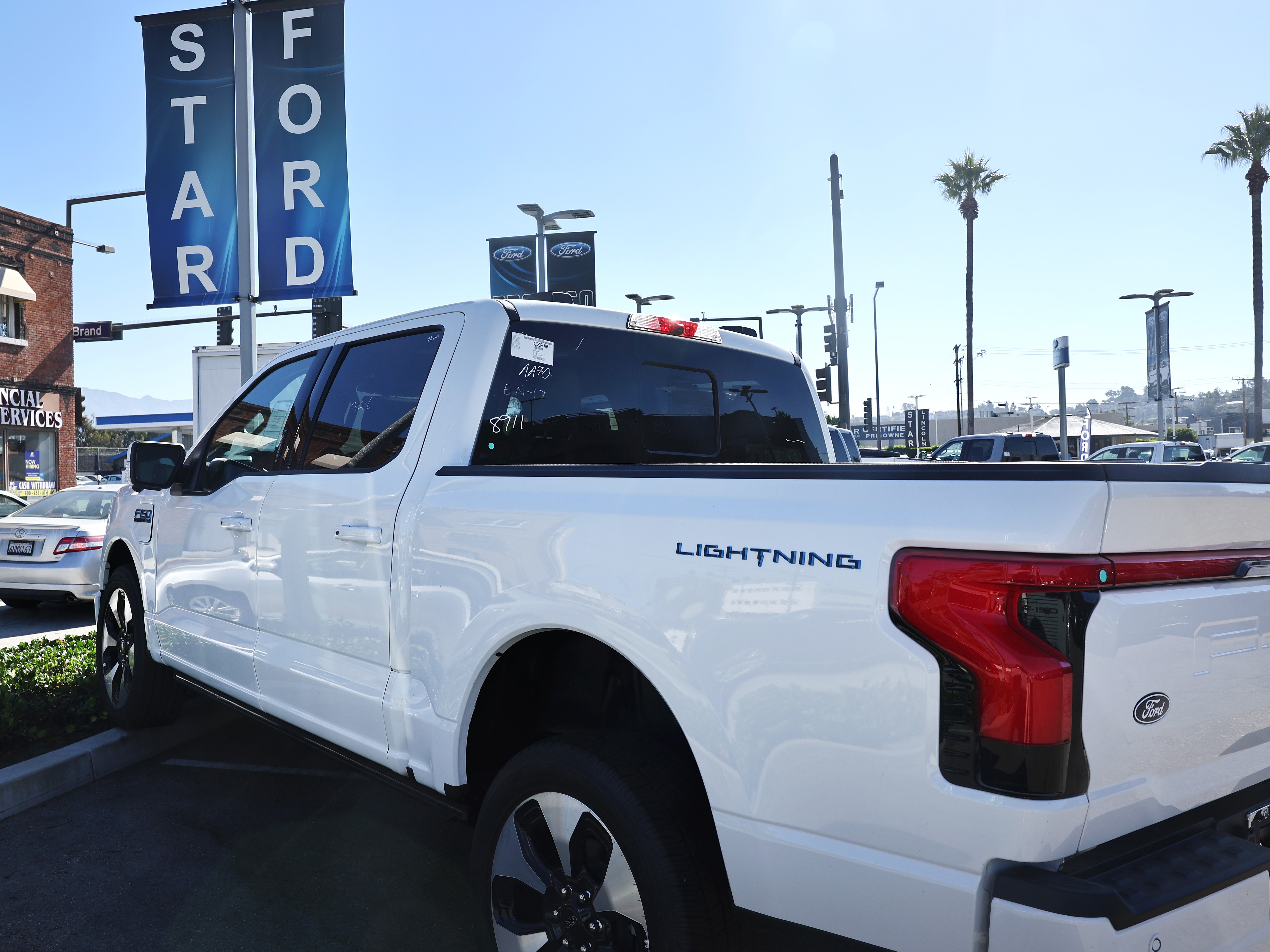 A Ford F-150 Lightning electric pickup truck is displayed for sale at a Ford dealership in Glendale, Calif., in August. Some car shoppers are hurrying to finalize EV purchases while they can still be certain to get a hefty federal tax incentive.