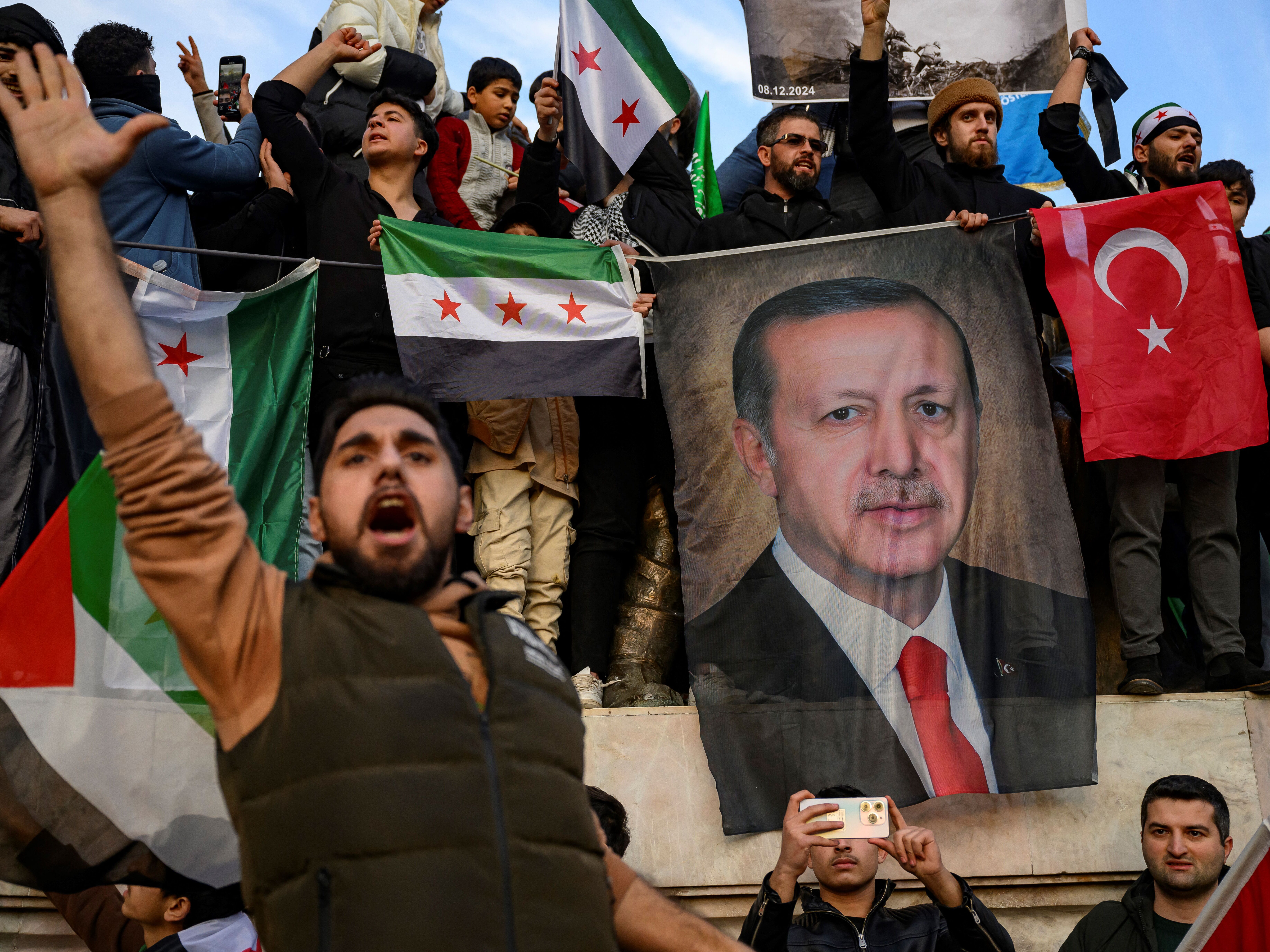 People hold a banner featuring Turkish President Recep Tayyip Erdogan as members of the Syrian community and supporters gather in Istanbul to celebrate the fall of Syrian President Bashar al-Assad in the face of an offensive by Islamist-led rebels, on Dec. 8.