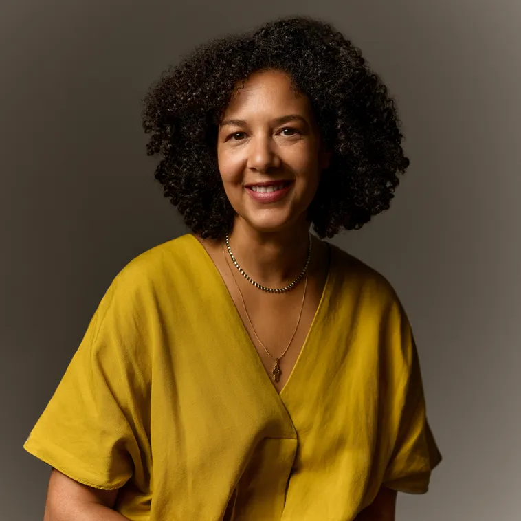 Woman in a yellow top with curly hair